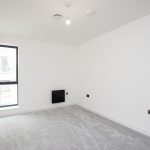 Empty room with grey carpet flooring.