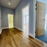 Bright, modern hallway with wooden flooring.