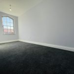 Empty room with grey walls and carpet.