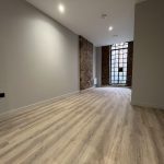 Spacious, modern room with wooden flooring.