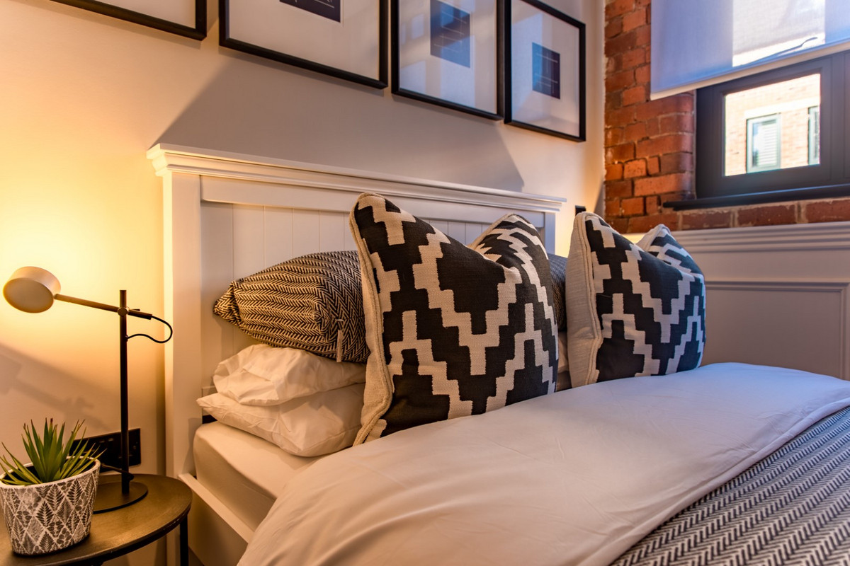 Stylish bedroom with patterned cushions.