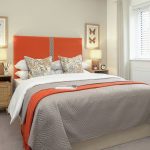 Modern bedroom with orange accents.