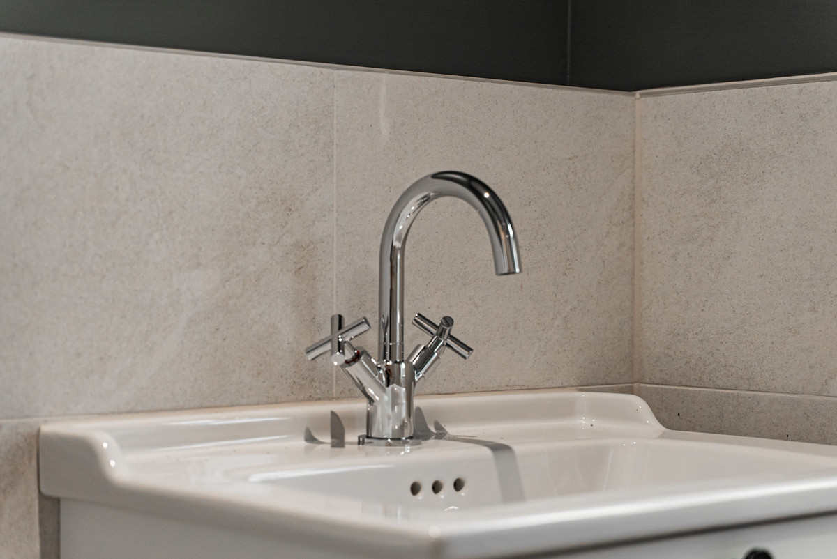 Modern chrome tap above white sink.