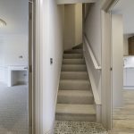 Modern interior with staircase and kitchen.