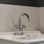 Modern chrome tap above white sink.