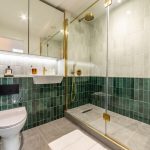 Modern bathroom with stylish green tiles.