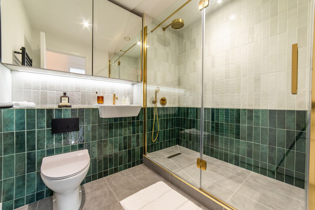 Modern bathroom with stylish green tiles.