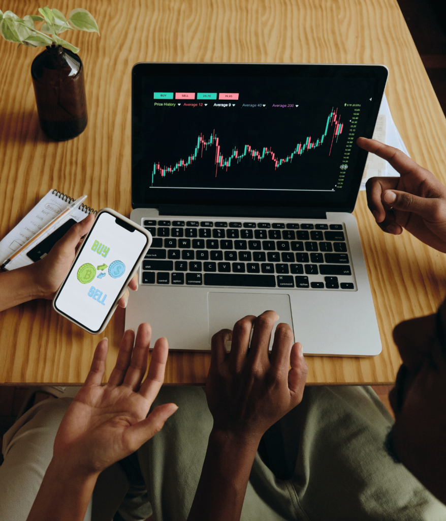 Hands using laptop and smartphone together.