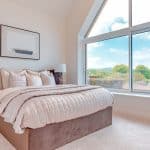 Luxurious bedroom with large window and countryside views