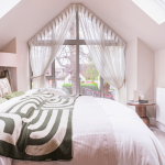 Bright, modern scandi inspired bedroom with large windows and subtle accents at Avon Bard. A bespoke four-bedroom home in Stratford Upon Avon.