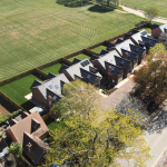 Aerial view of six bespoke four-bedroom houses in Stratford Upon Avon, Warwickshire with large landscaped gardens and overlooking a beautiful sports field to the rear of the properties.