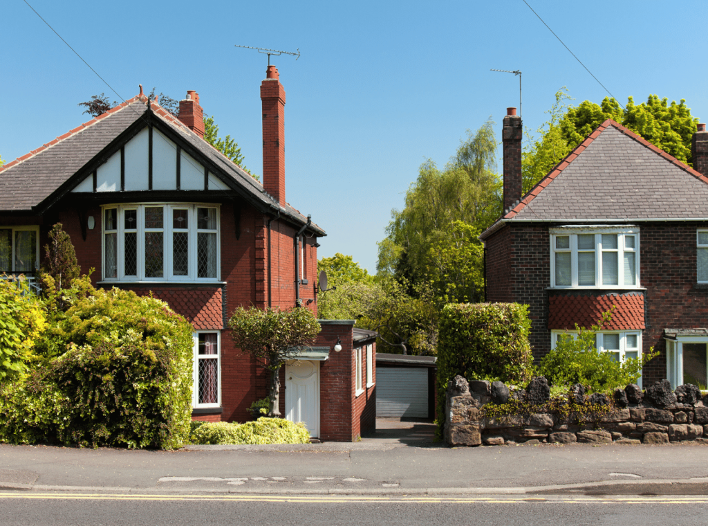 Two traditional houses with gardens.