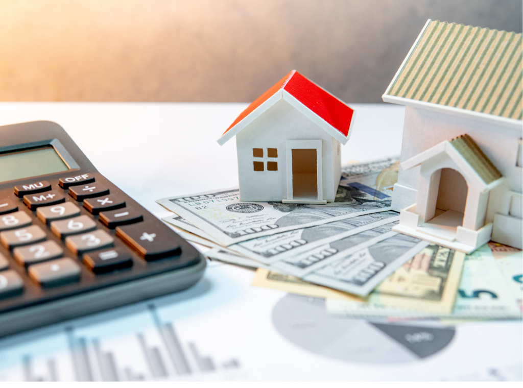 Calculator, houses, euros and dollar bills on a paper with a pie chart.